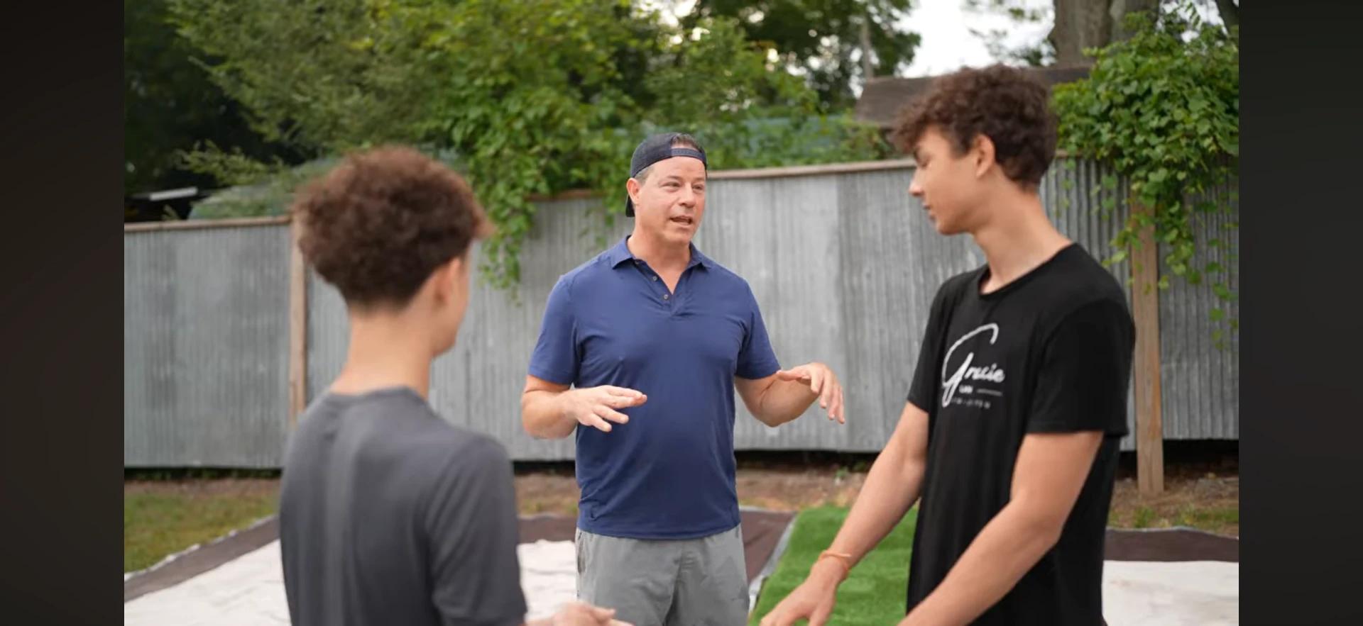 Bill Wilder coaching two young men outdoors before a group session